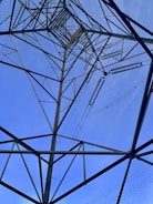 Close-up of a transmission tower frame being welded by skilled workers.