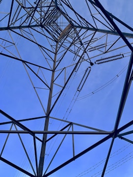 Close-up of a transmission tower frame being welded by skilled workers.