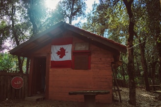 brown wooden house with us a flag on top