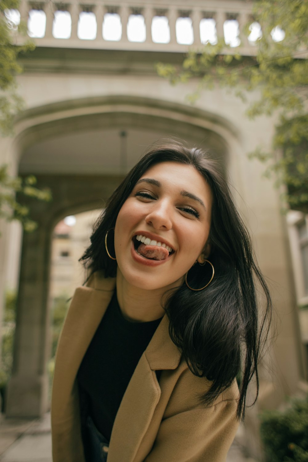 femme en manteau brun souriant