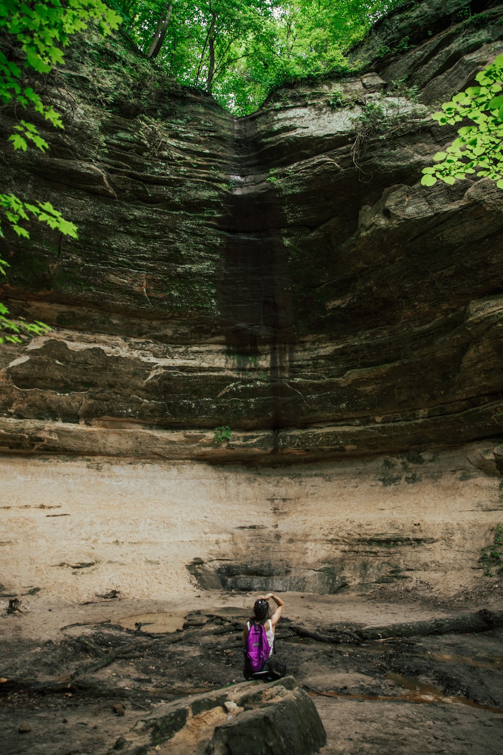 person in black jacket standing near brown rock formation during daytime