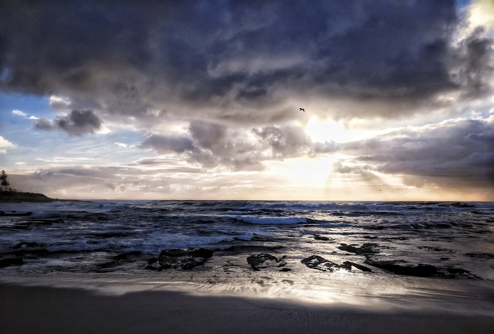 Olas del océano rompiendo en la costa durante la puesta de sol