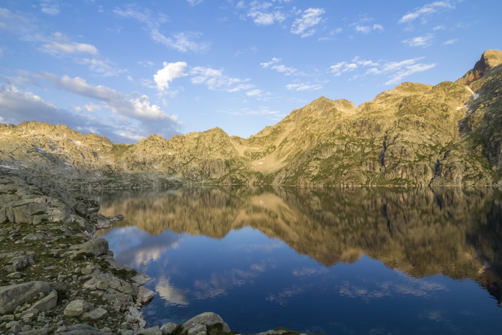 lake in the middle of mountains during daytime