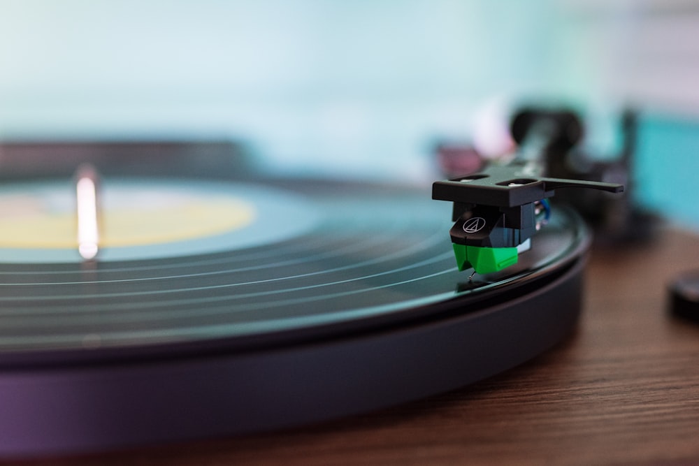 black vinyl record player on brown wooden table