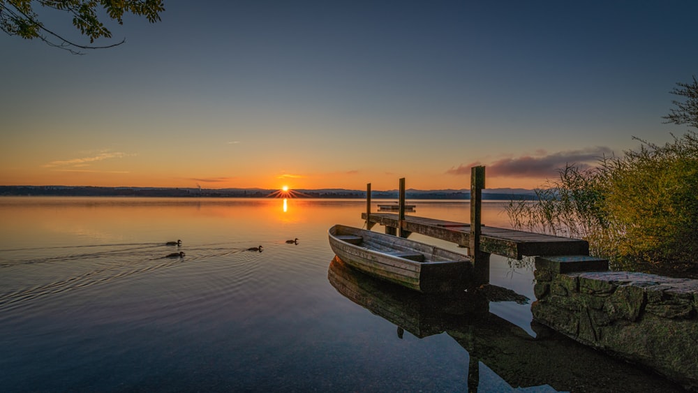 white boat on water during sunset