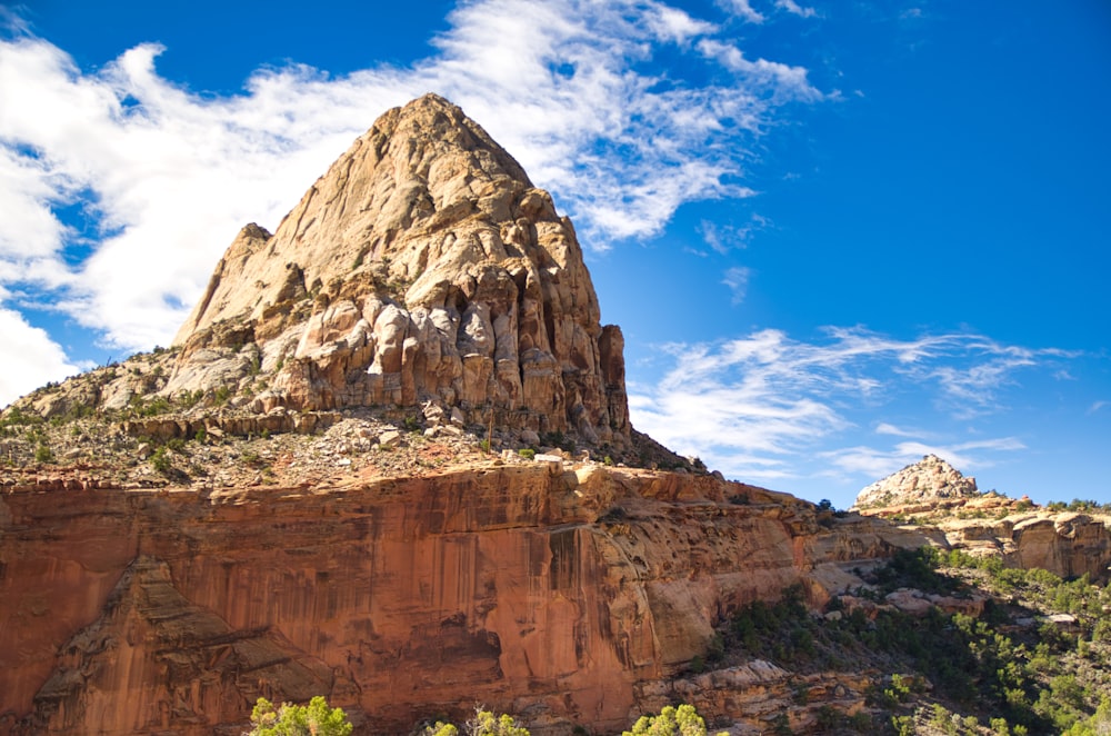 brown rock formation under blue sky and white clouds during daytime