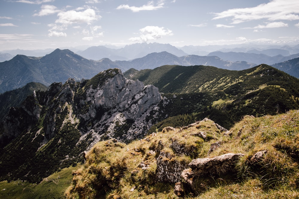 montagna verde e marrone sotto nuvole bianche durante il giorno