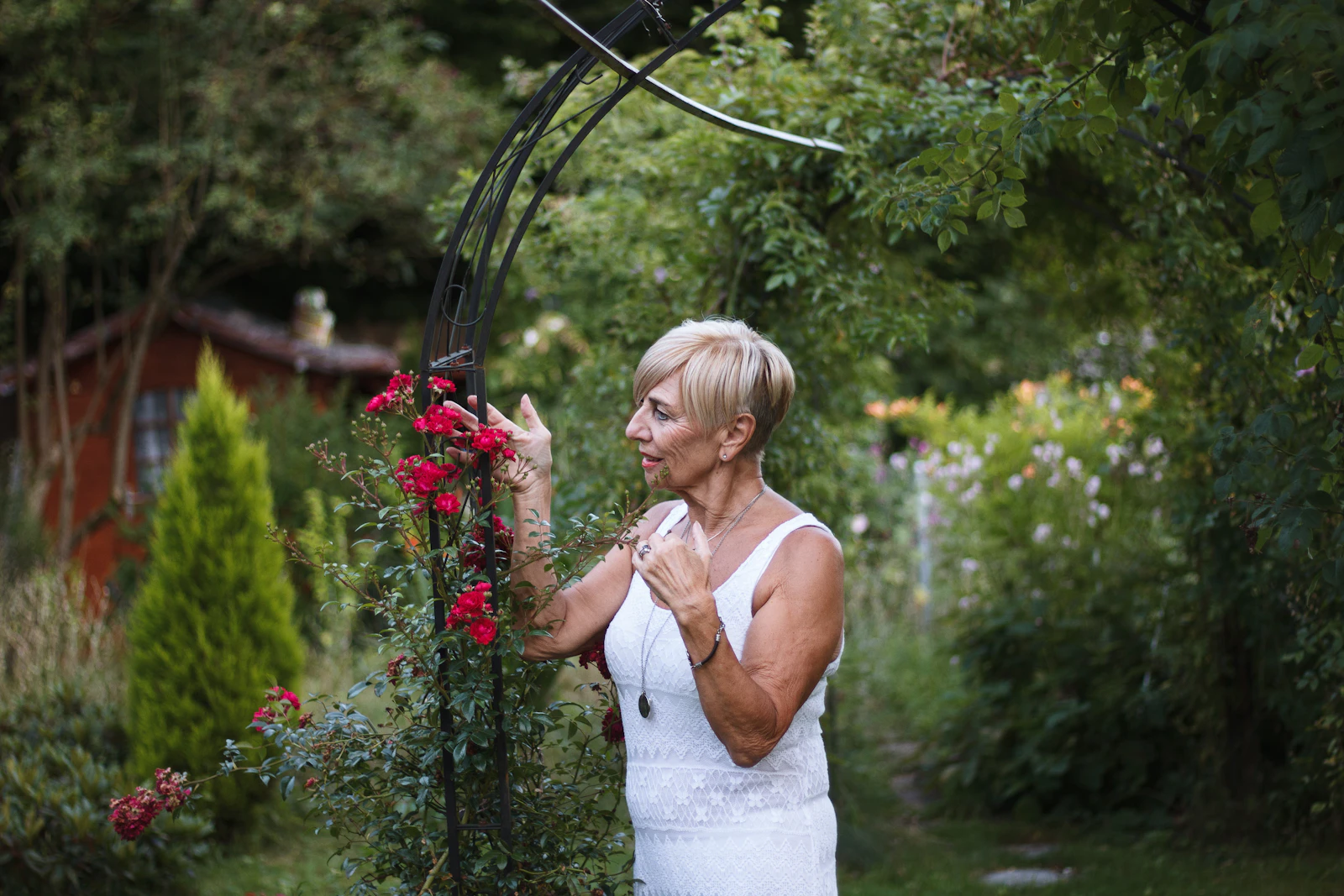 Femme épanouie s’occupant de ses rosiers dans un jardin