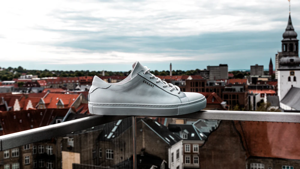White leather sneaker above a city skyline