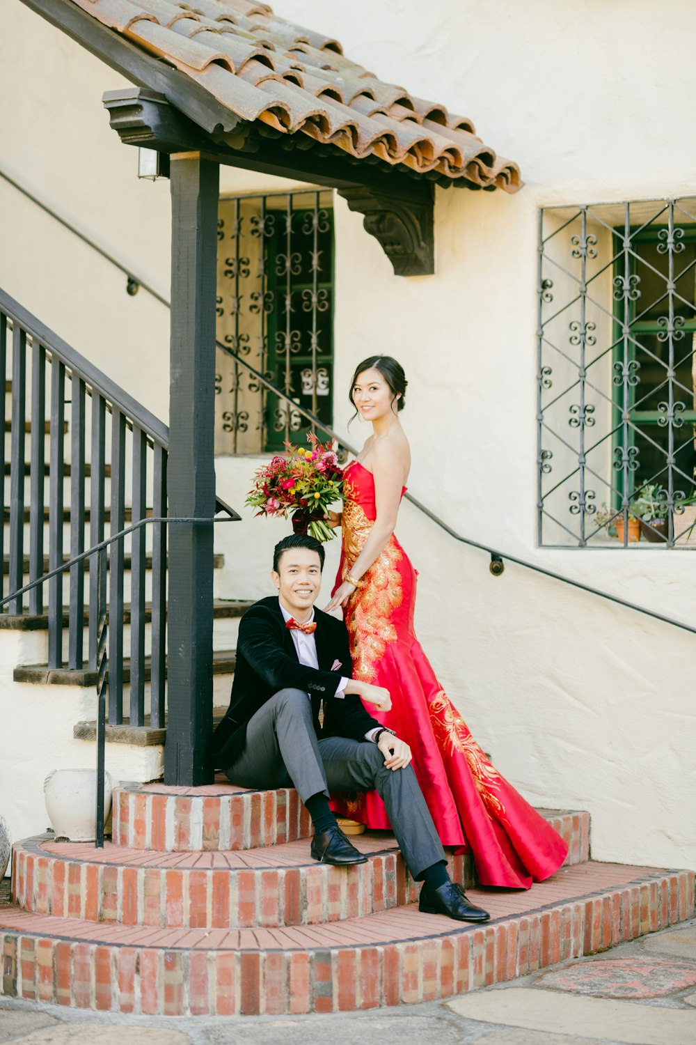 man in black suit jacket and woman in red dress