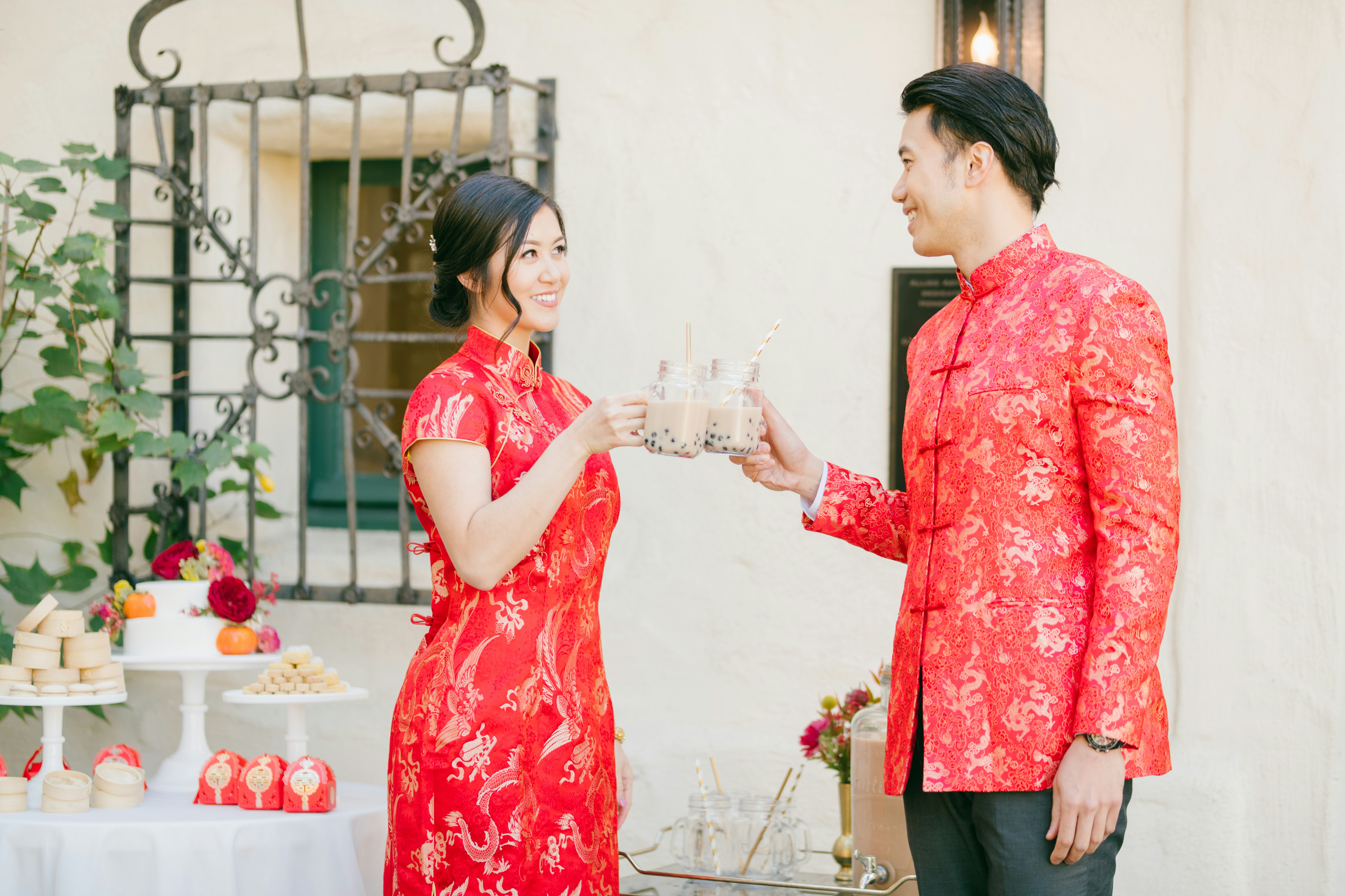 woman in red and white floral dress holding clear drinking glass