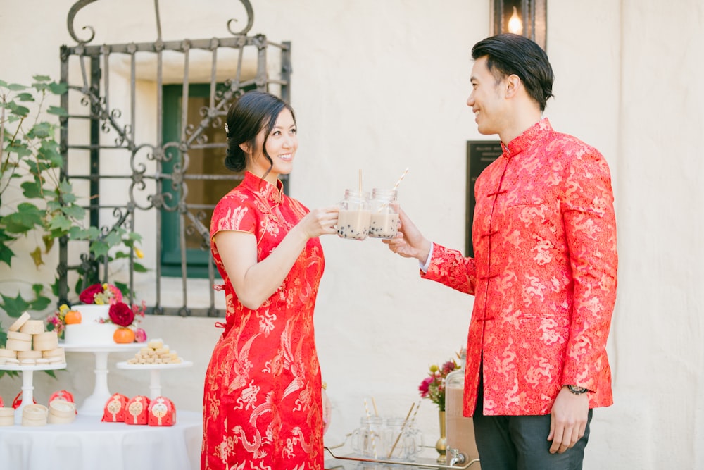 woman in red and white floral dress holding clear drinking glass