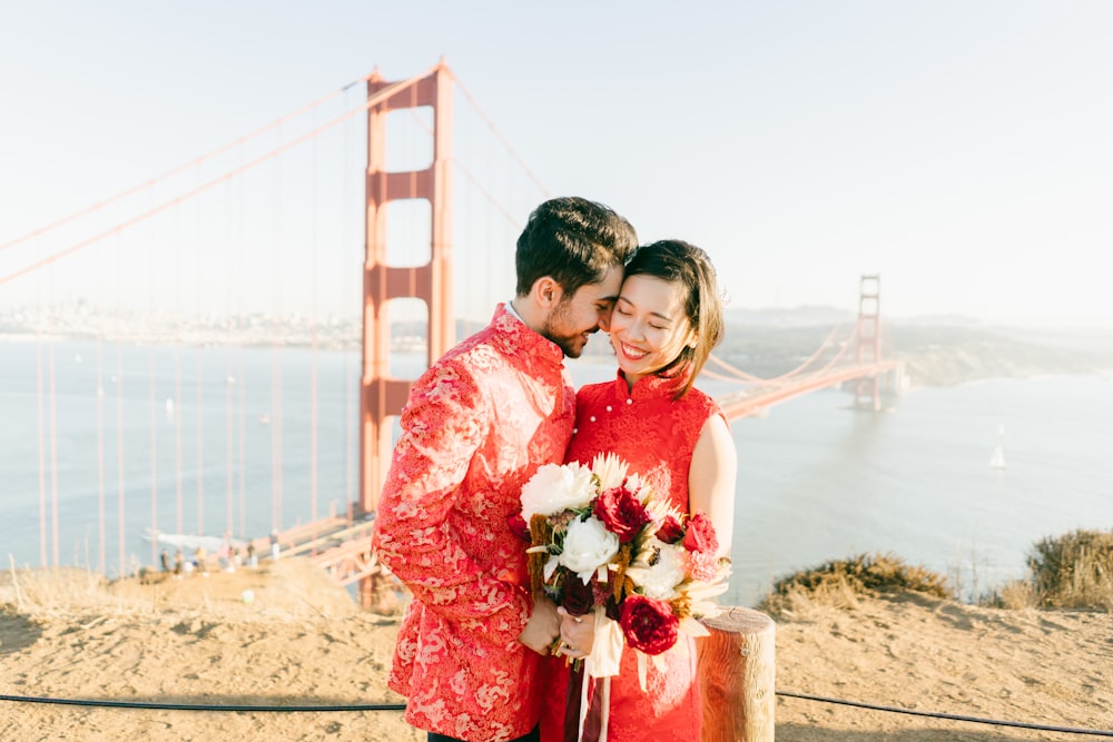 man in red crew neck t-shirt holding bouquet of flowers