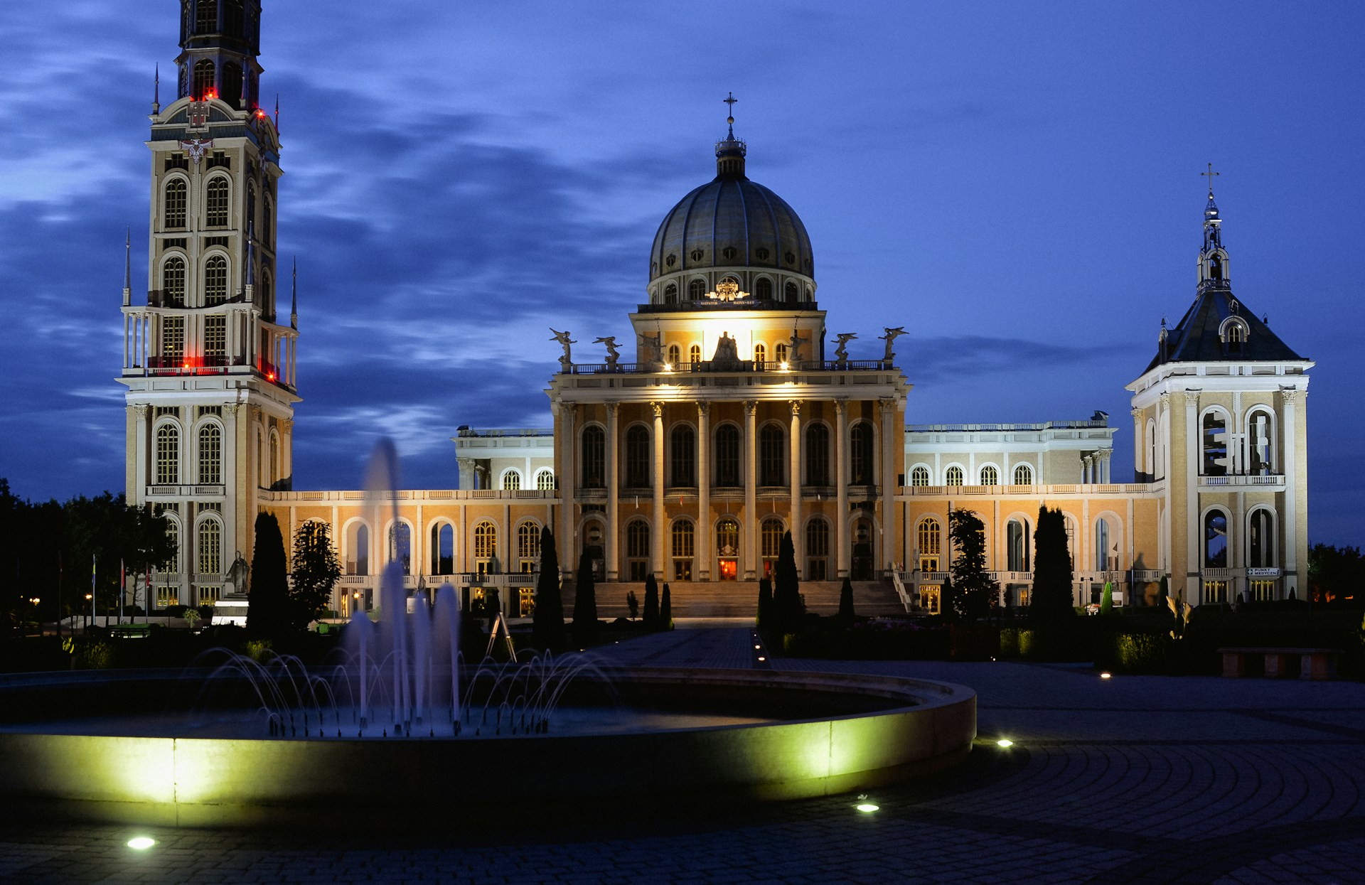Twilight casting a golden glow over the Basilica of Saint Anthony, its silhouette mirrored in the calm waters nearby.
