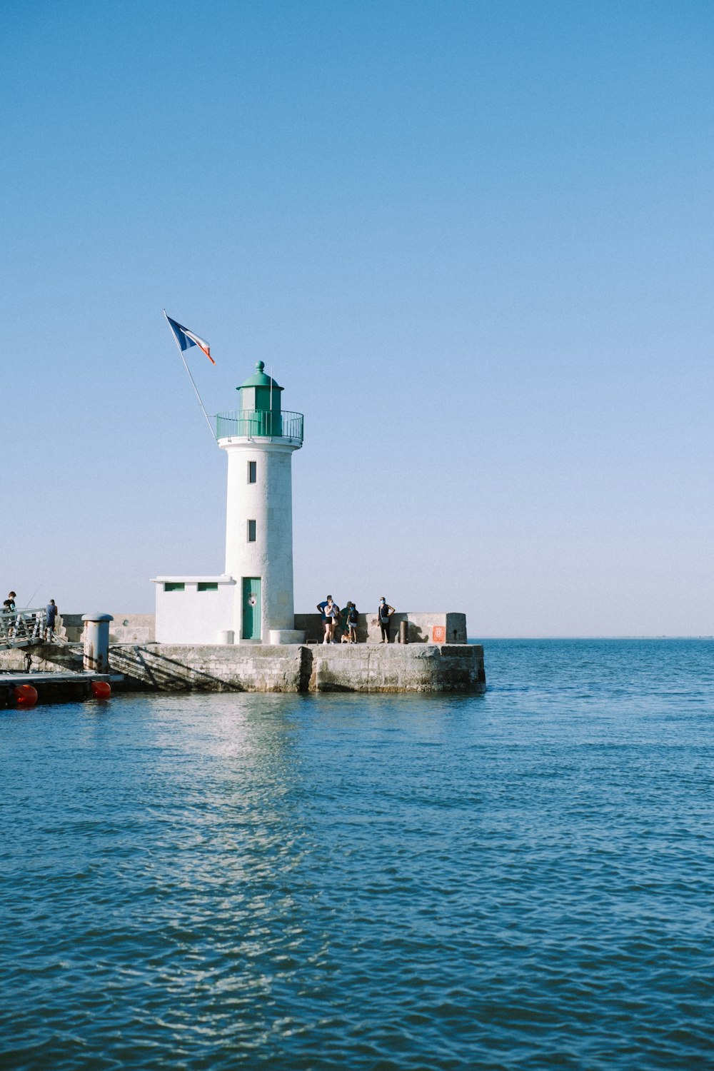 Phare blanc sur le quai pendant la journée