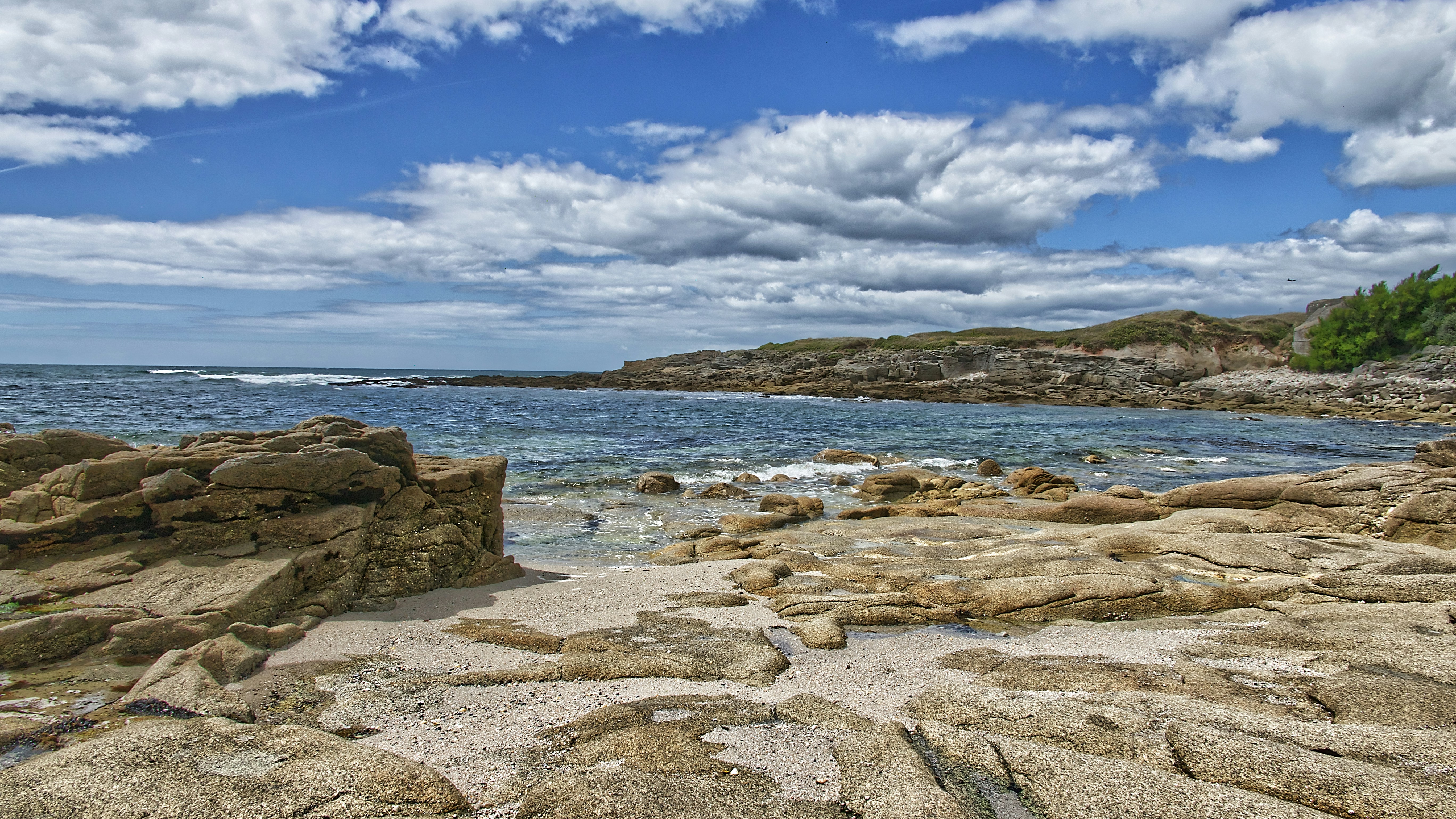 brown rocks on seashore under blue sky and white clouds during daytime