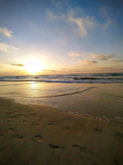 Sunset view over a calm Mediterranean beach with gentle waves lapping the shore
