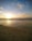 A scenic view of a sunset over a tranquil beach.