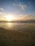 A serene sunset view over a Balinese beach with gentle waves and soft sand.