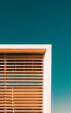 white window blinds on blue wall
