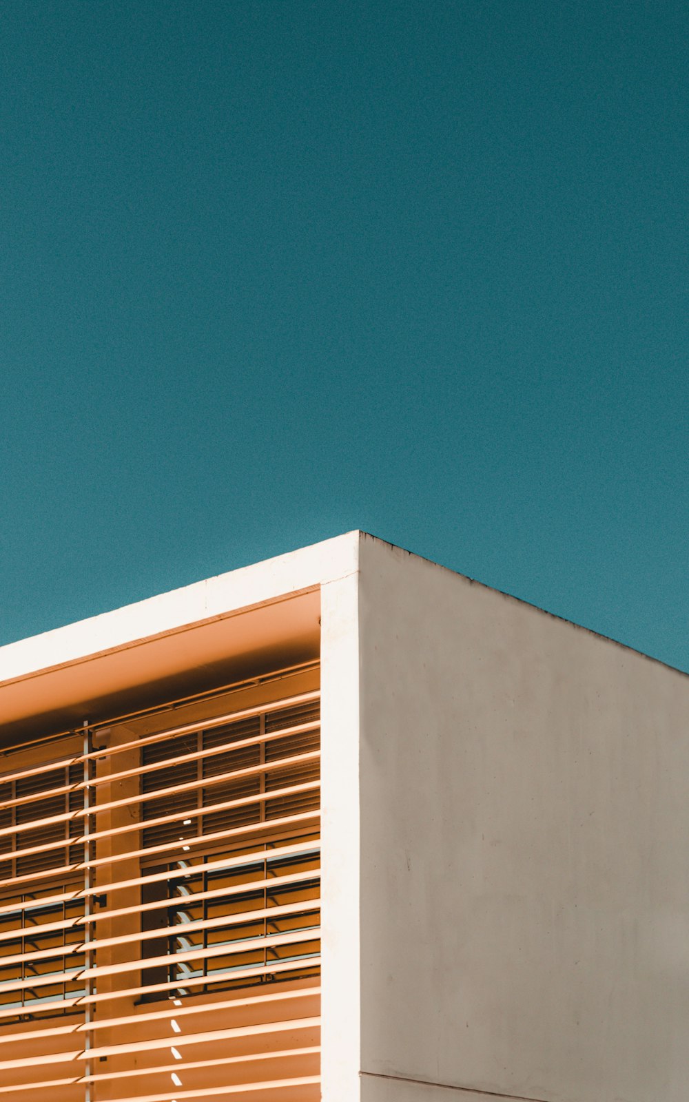 Weißes Betongebäude unter blauem Himmel tagsüber