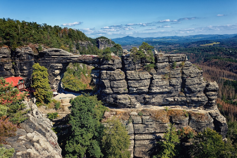 green trees on rocky mountain under blue sky during daytime