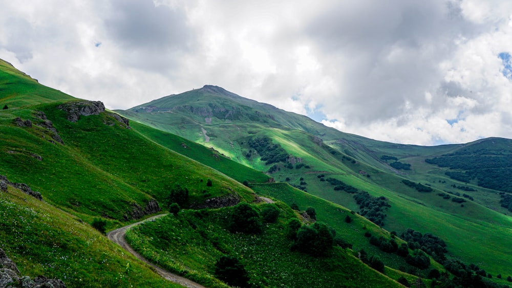 green mountain under white clouds during daytime