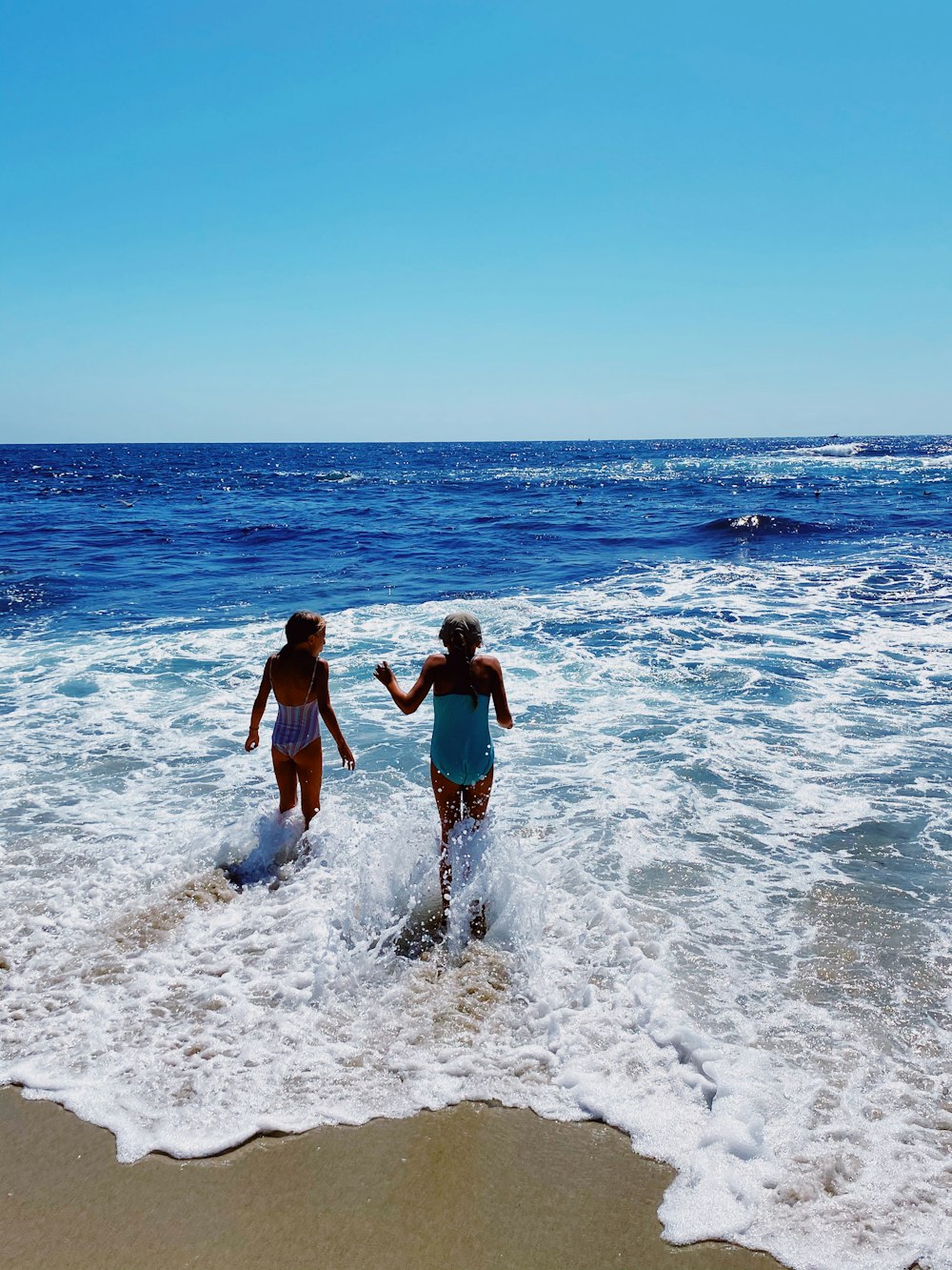 2 men and woman standing on beach during daytime