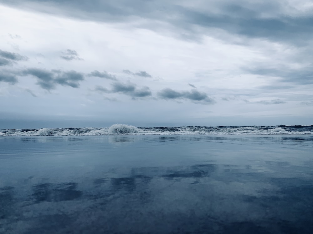 ocean waves under cloudy sky during daytime