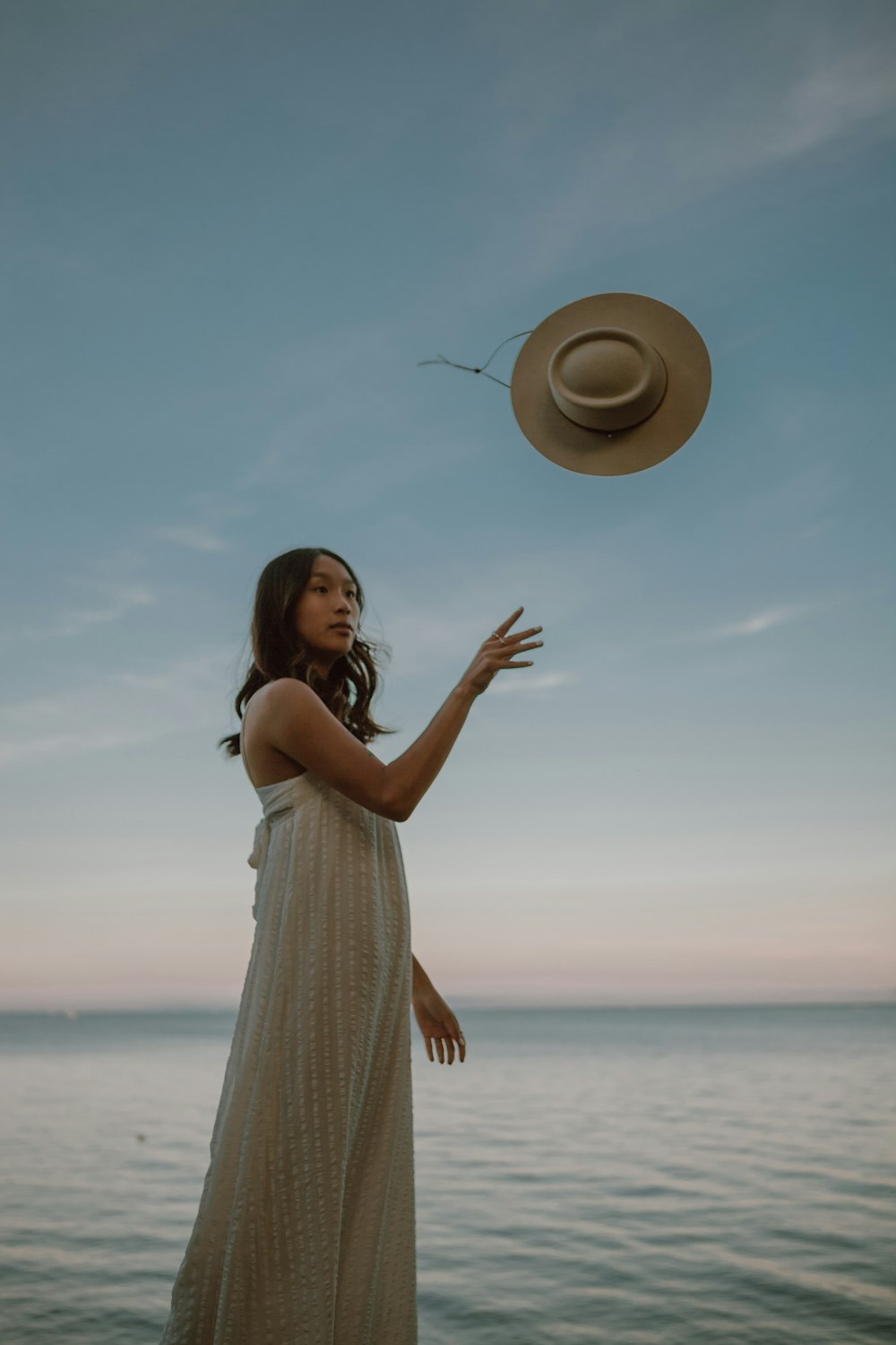 woman in white dress standing on beach during daytime