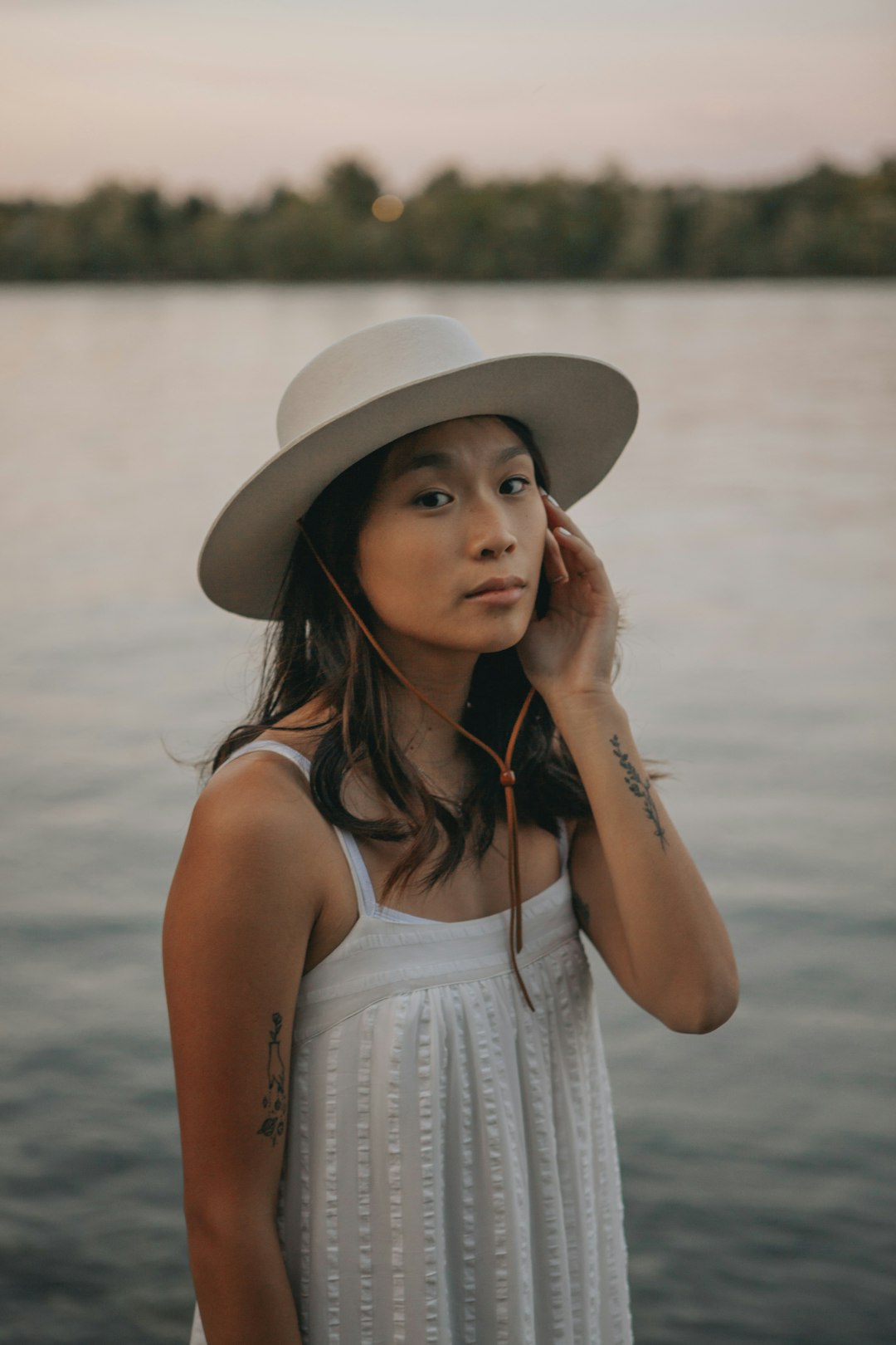 woman in white tank top wearing brown sun hat