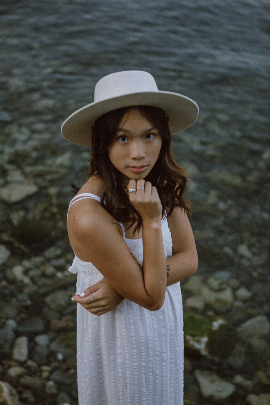 woman in white and pink stripe tank dress wearing white sun hat