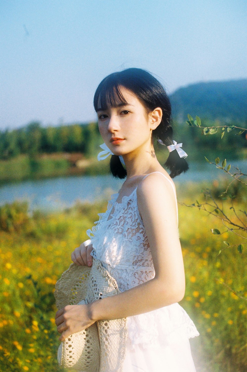 woman in white floral dress standing on yellow flower field during daytime