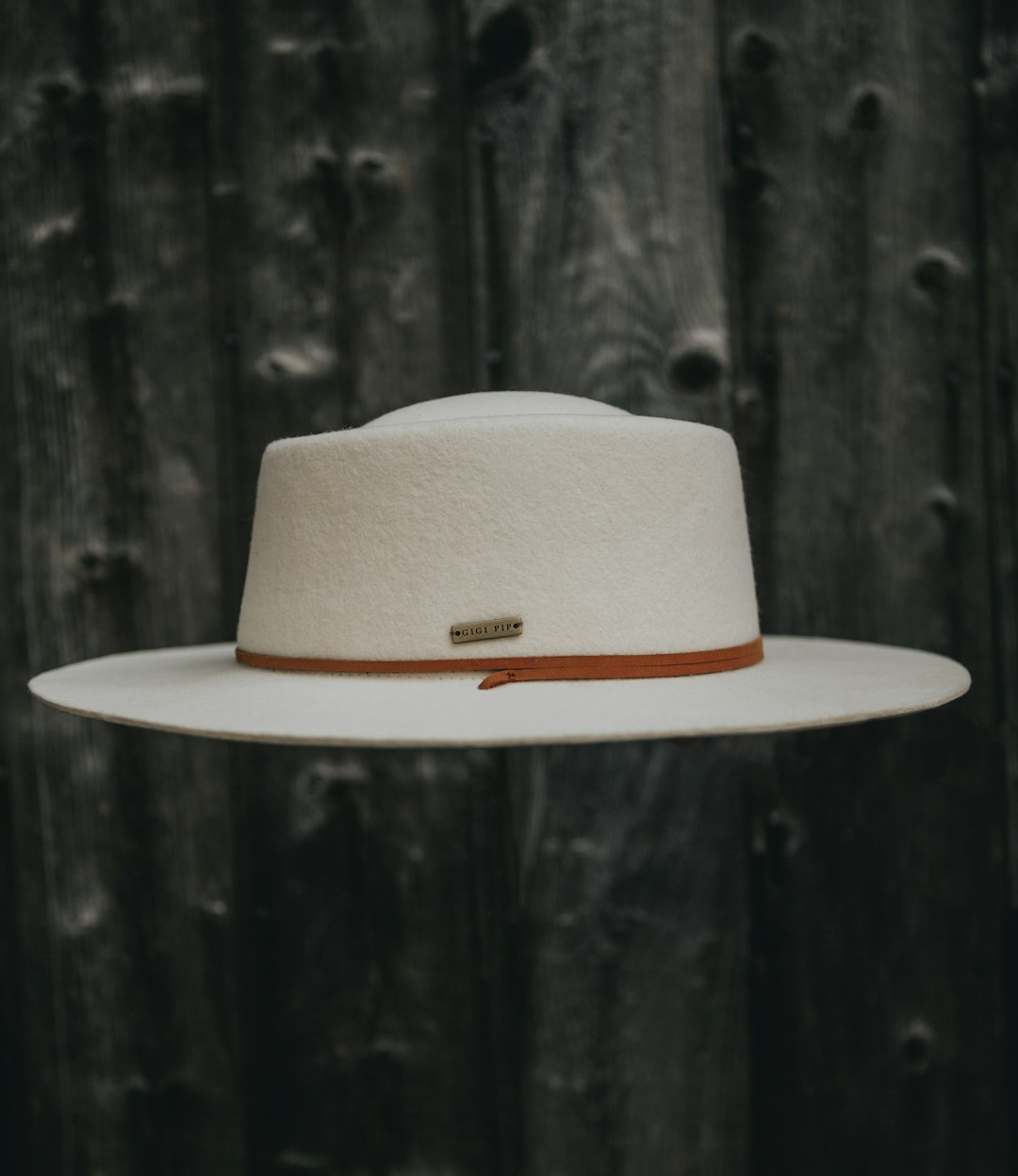 white fedora hat on black wooden surface