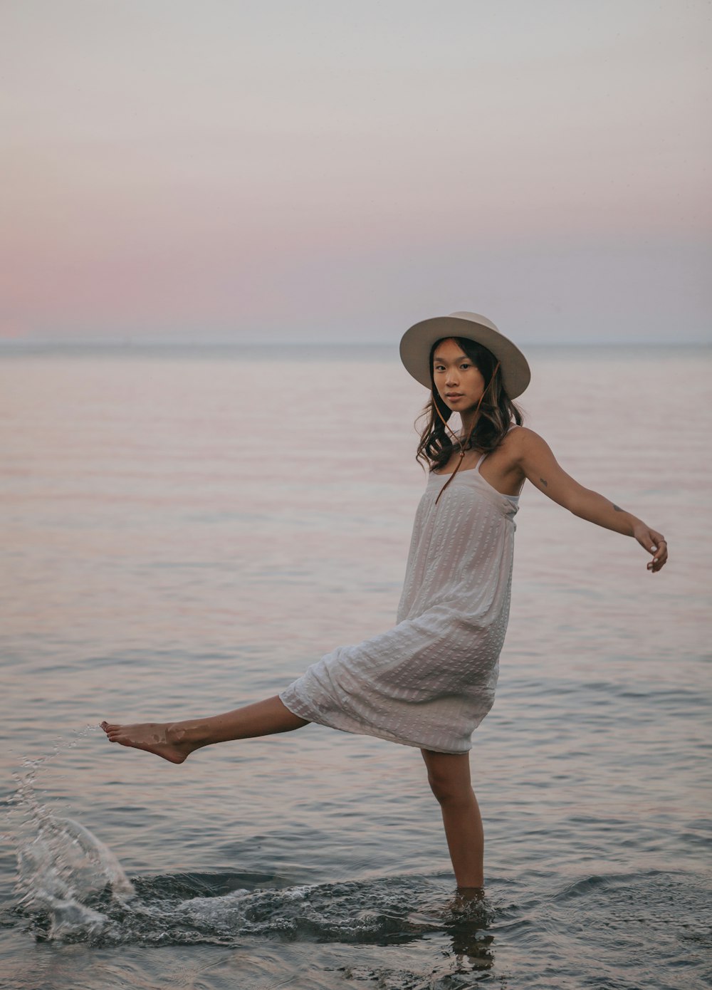 woman in white dress standing on sea water during daytime