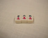 Side view of a feminine, sophisticated mahjong mat rolled gently on a clean white surface.