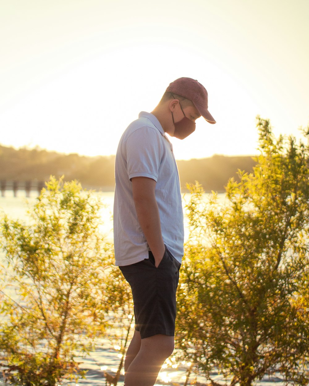 man in white t-shirt and black pants standing on green grass field during daytime