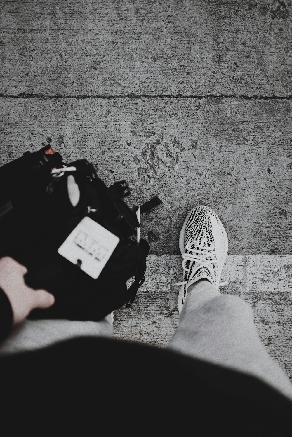 person wearing black and white adidas sneakers