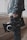 A person holds a professional video camera, wearing a denim jacket. The camera appears to be a high-end model, possibly used for filmmaking or professional video production.