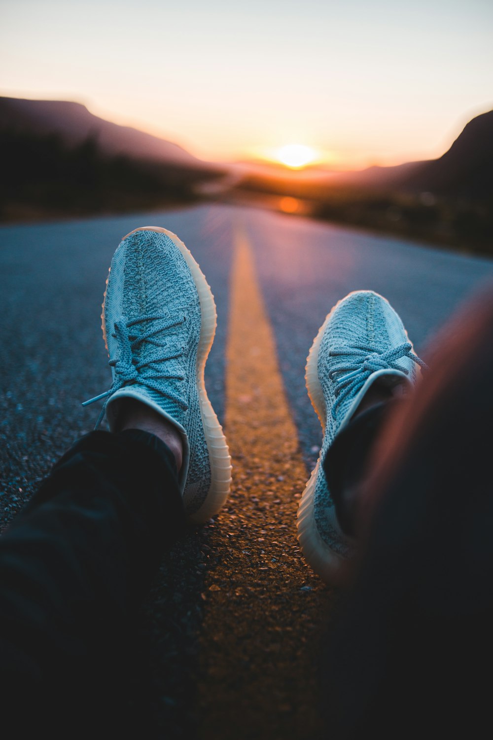 person in black pants wearing gray sneakers