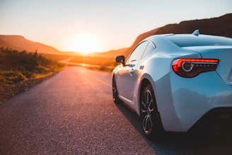 white porsche 911 on road during sunset