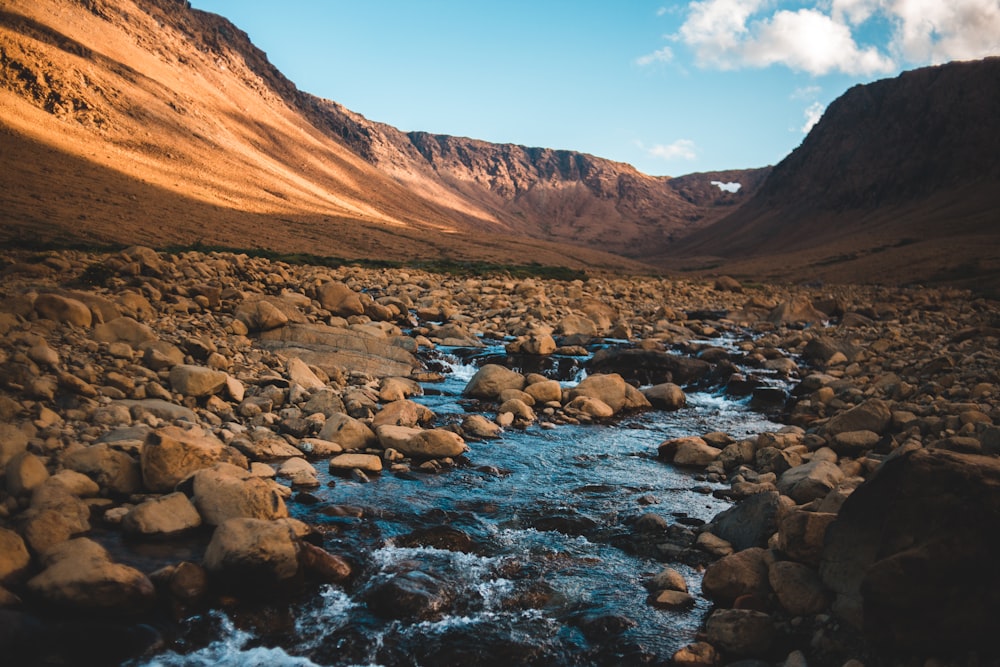 brown rocky mountain near river during daytime