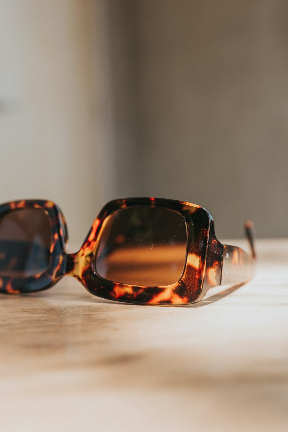brown framed sunglasses on white table