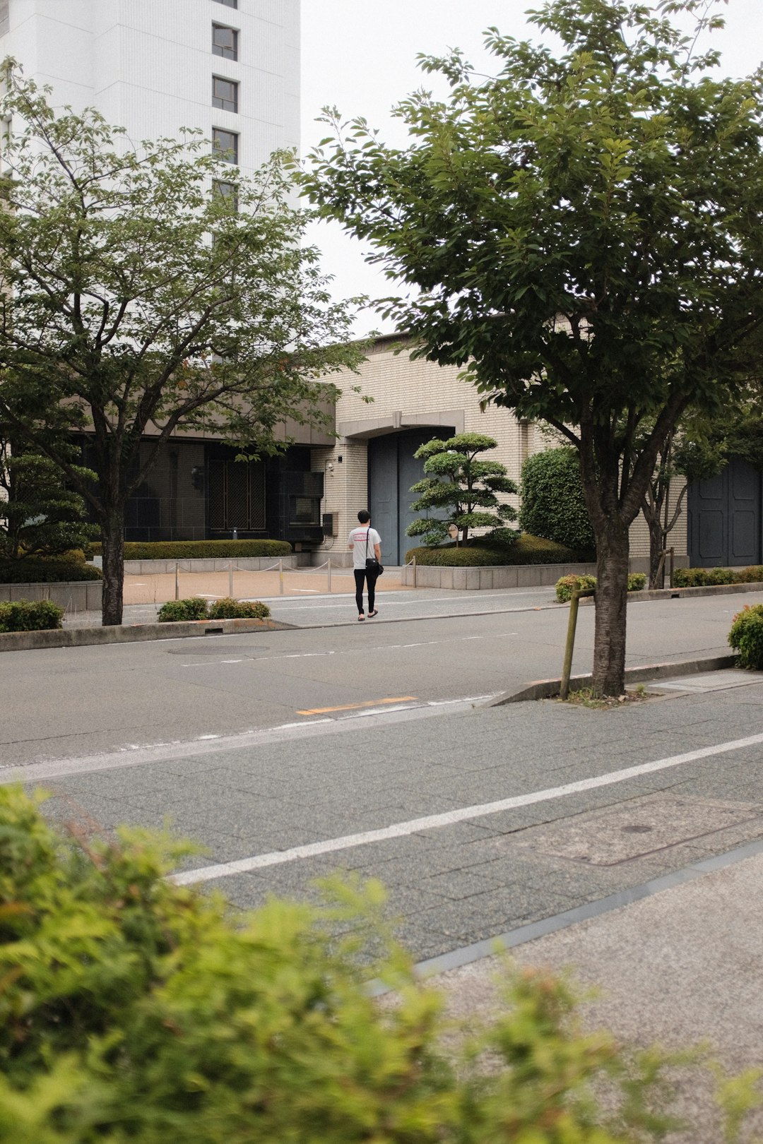 man in black jacket and black pants walking on sidewalk during daytime