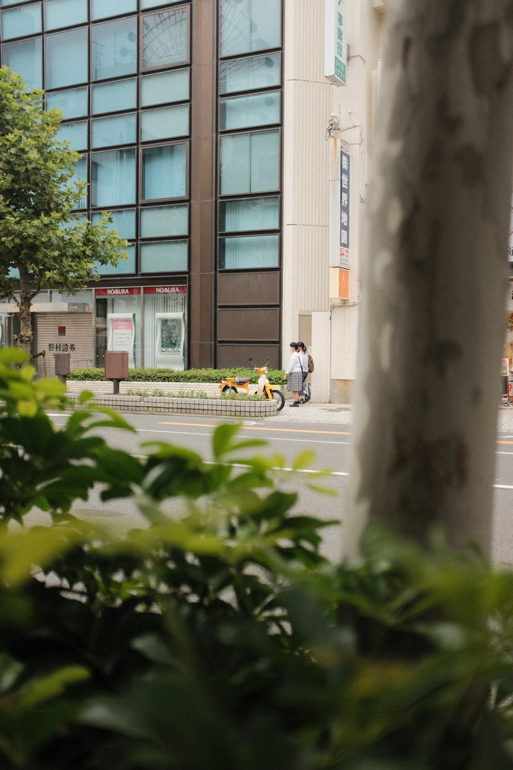 persona in giacca nera e pantaloni neri in sella alla bicicletta gialla su strada durante il giorno