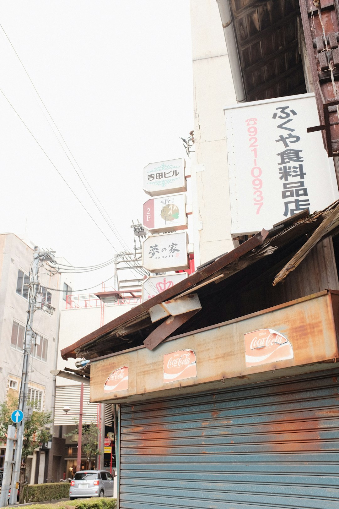 brown wooden houses near white concrete building during daytime