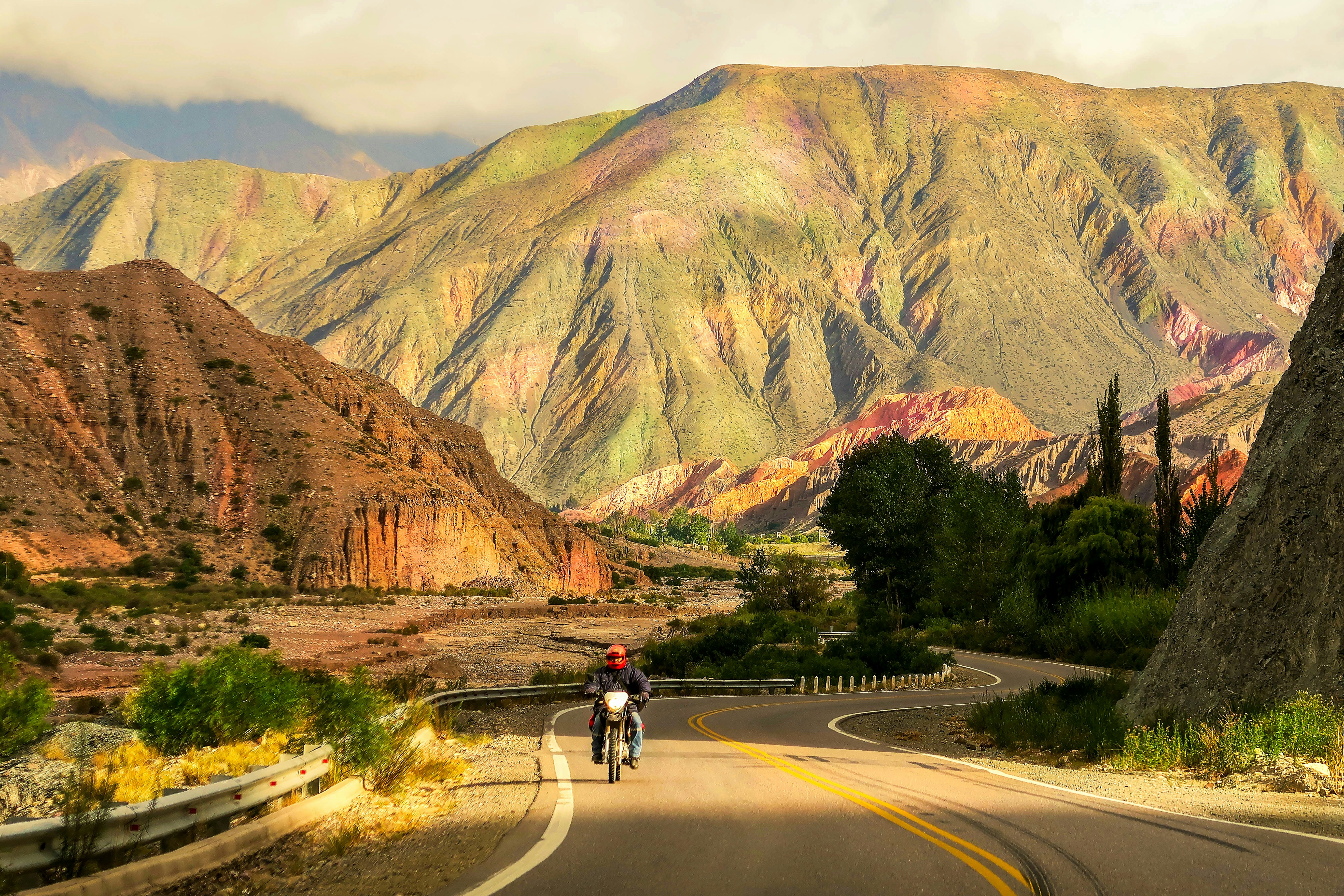 Hombre montando en bicicleta en un camino cerca de la montaña durante el día