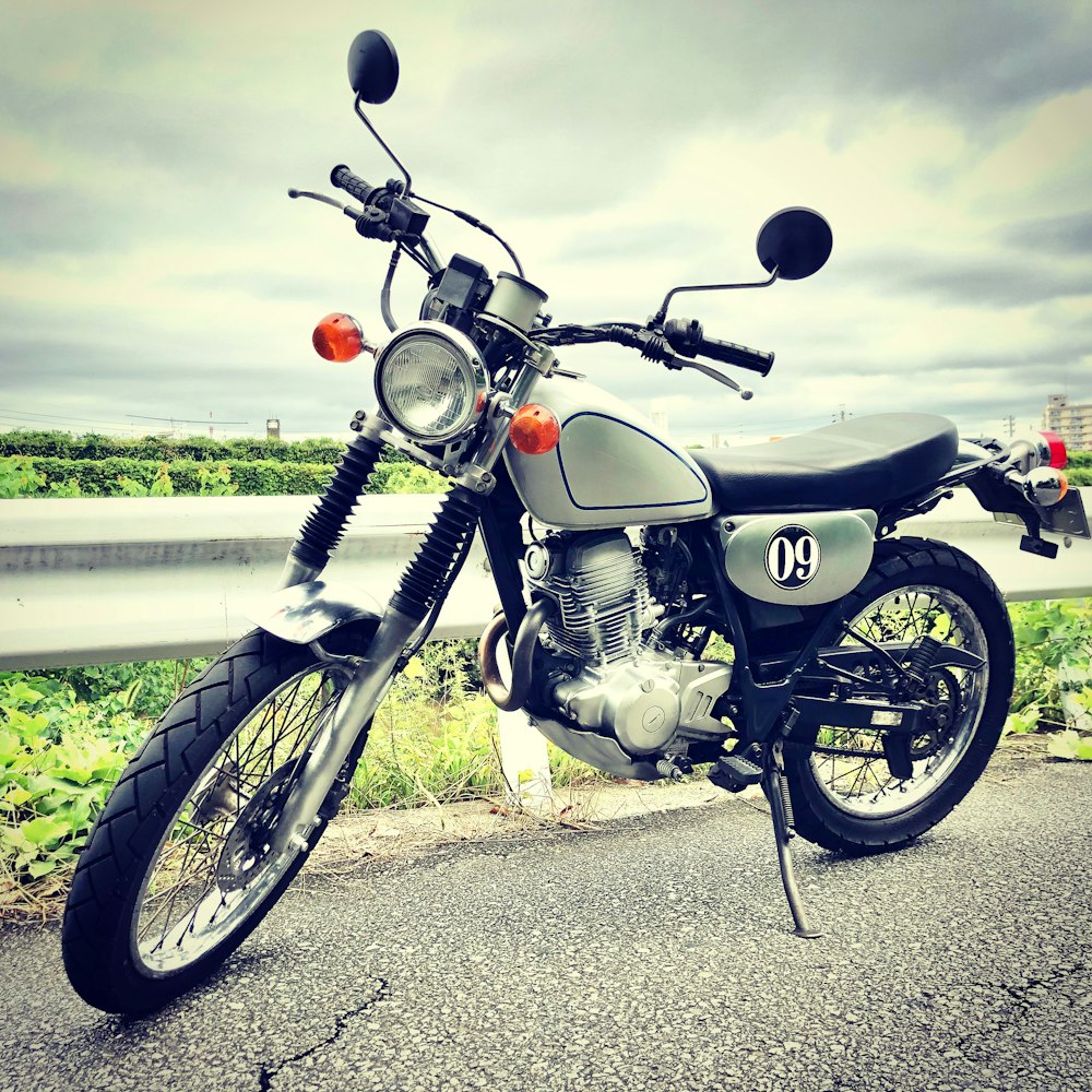 black and silver cruiser motorcycle on gray asphalt road during daytime