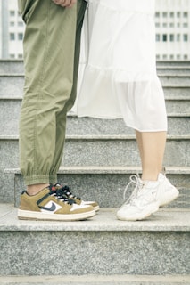 person in white pants and blue and white nike sneakers