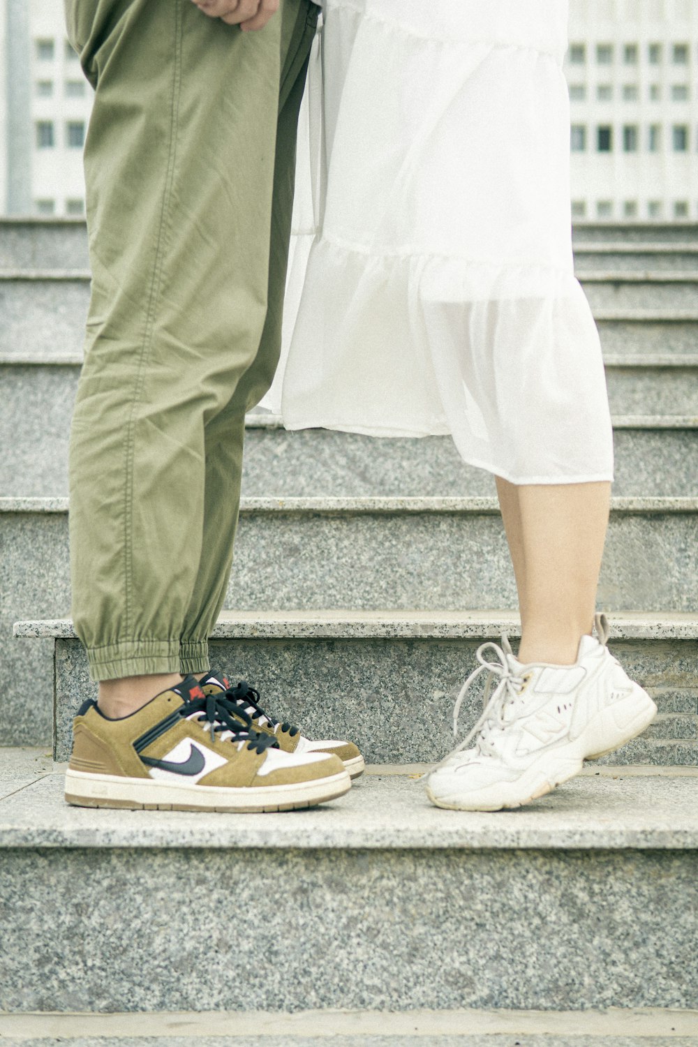 person in white pants and blue and white nike sneakers